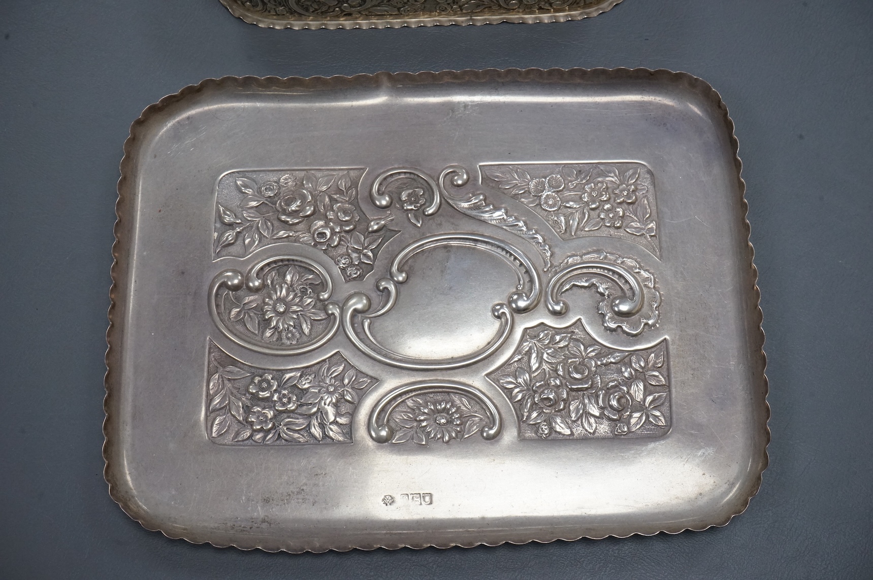 An early 20th century repousse silver dressing table tray by William Comyns & Sons Ltd, London, 1901, 25.1cm, together with a matching oval trinket box, London, 1900, 16.6oz (a.f.).